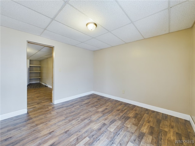 spare room with wood-type flooring and a drop ceiling