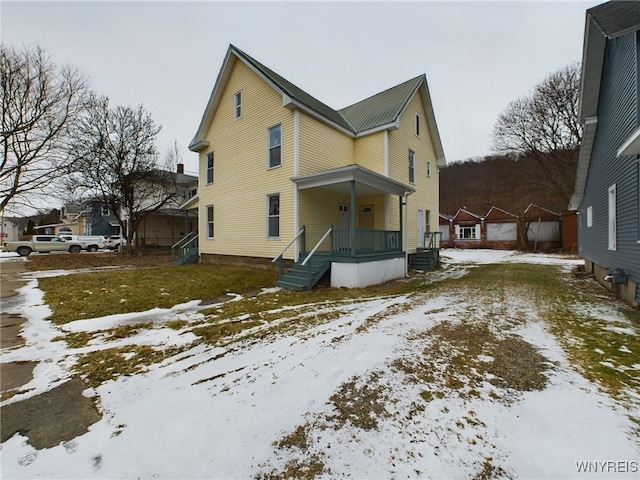 snow covered rear of property featuring cooling unit