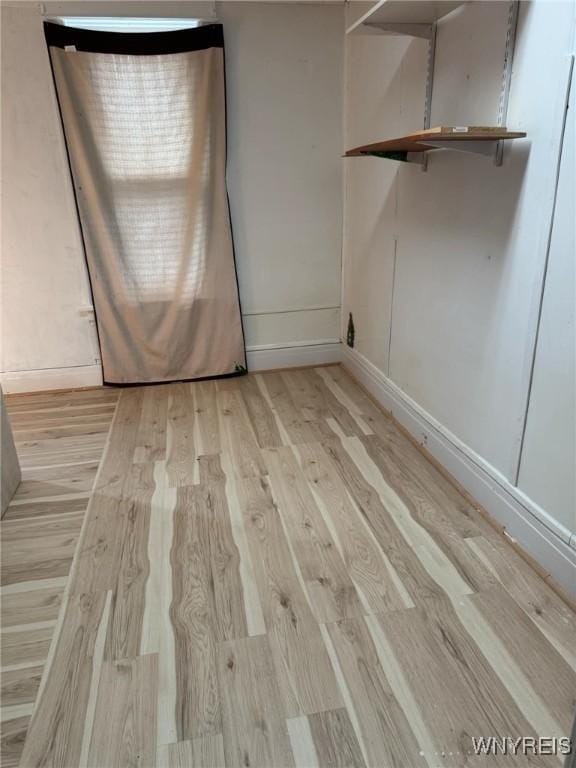 unfurnished room featuring wood finished floors and baseboards