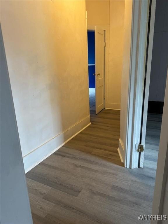 hall with dark wood-style floors and baseboards