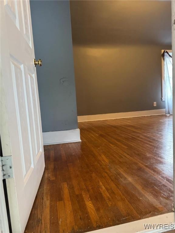 empty room with baseboards and wood finished floors