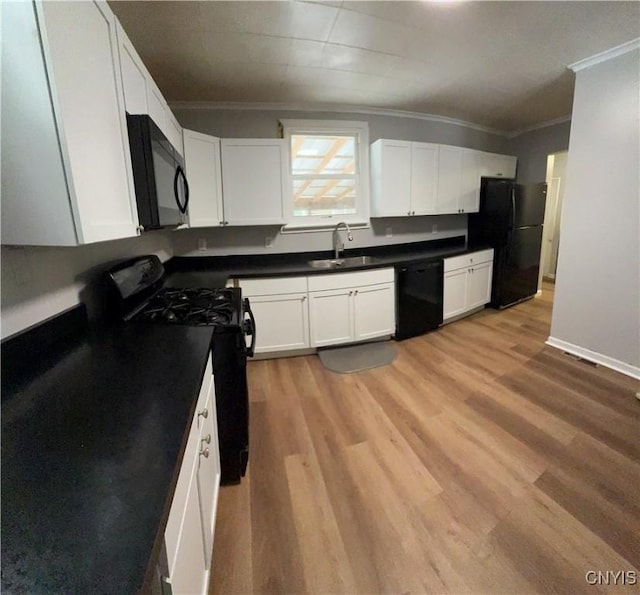 kitchen with white cabinetry, ornamental molding, sink, and black appliances