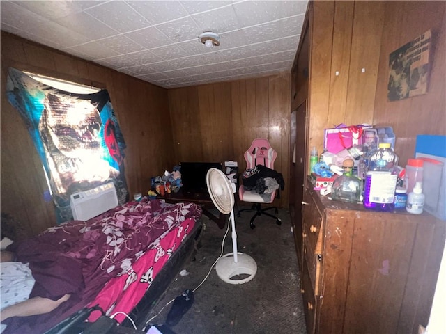 carpeted bedroom featuring wood walls