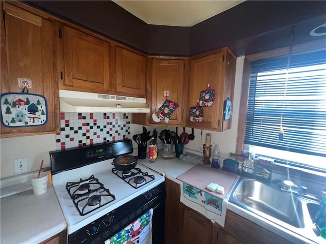 kitchen featuring sink, backsplash, and white range with gas stovetop