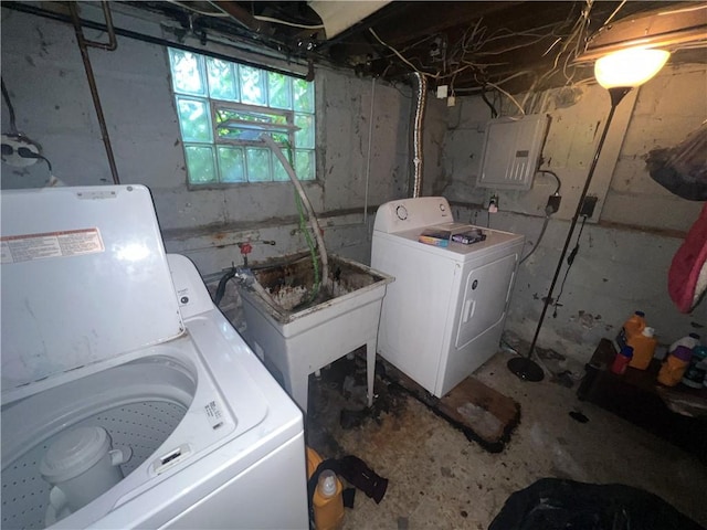 clothes washing area featuring washing machine and clothes dryer, electric panel, and sink