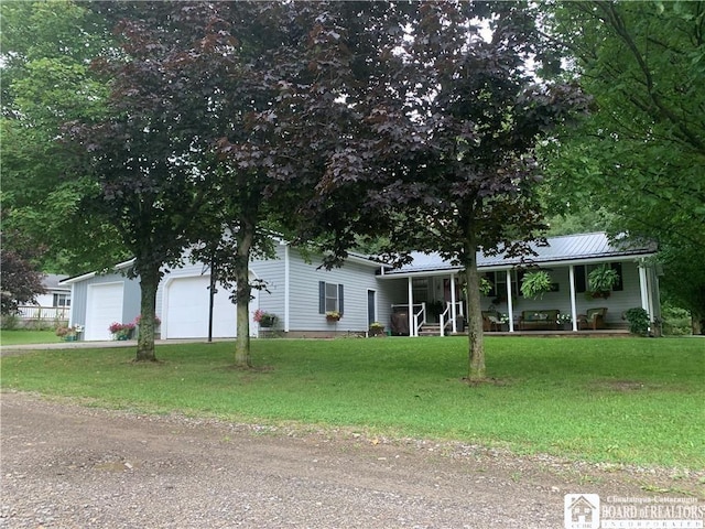 view of front of property with a garage, covered porch, and a front lawn