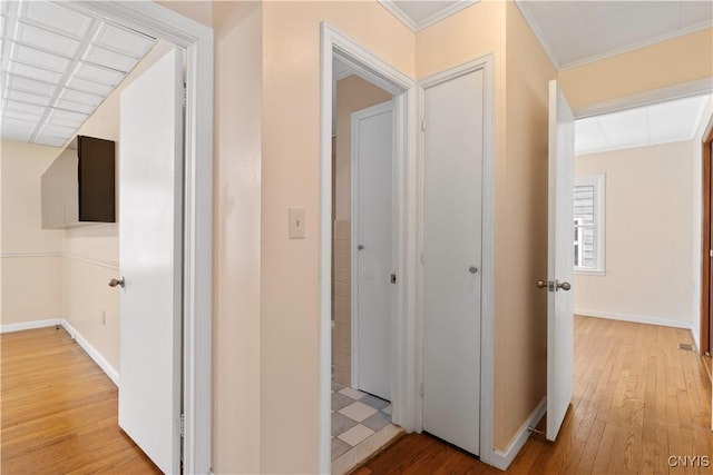 corridor featuring ornamental molding and light hardwood / wood-style floors