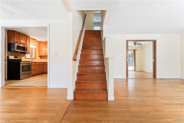 stairway with hardwood / wood-style flooring, ceiling fan, and crown molding