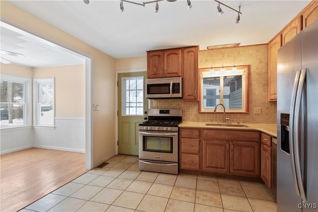 kitchen featuring sink, light tile patterned floors, backsplash, and appliances with stainless steel finishes