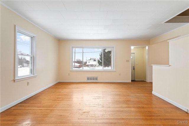 unfurnished room featuring crown molding, a wealth of natural light, and light hardwood / wood-style floors