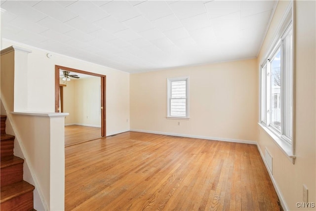 empty room with crown molding and light wood-type flooring