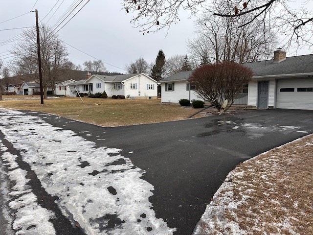 exterior space with a garage and a lawn