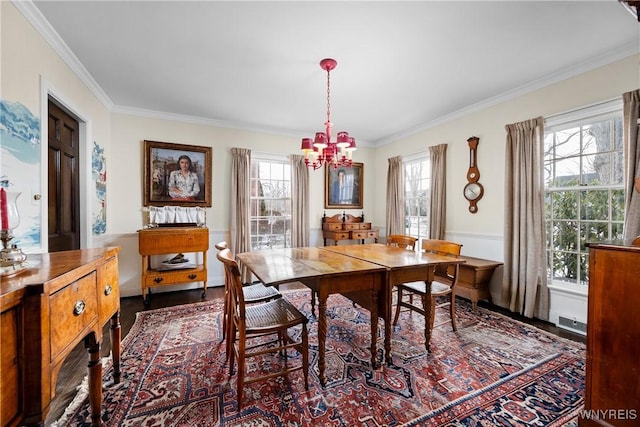 dining space featuring a notable chandelier, hardwood / wood-style flooring, and ornamental molding