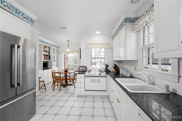 kitchen with sink, high end refrigerator, white cabinets, ornamental molding, and white stove