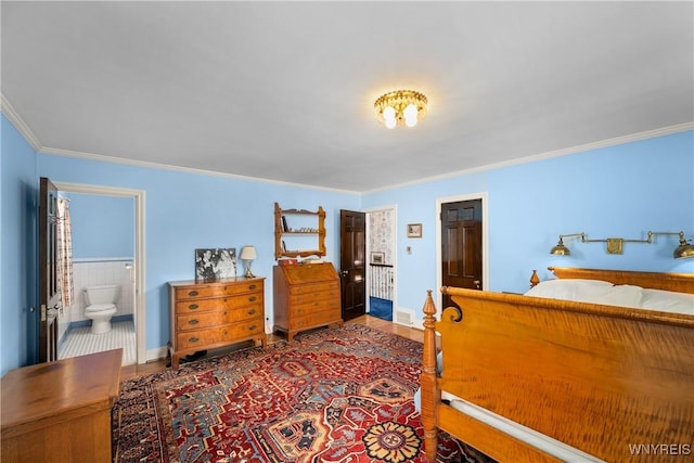 bedroom featuring crown molding, connected bathroom, and hardwood / wood-style floors