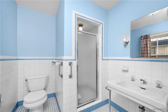 bathroom featuring sink, tile walls, toilet, a shower with door, and tile patterned floors