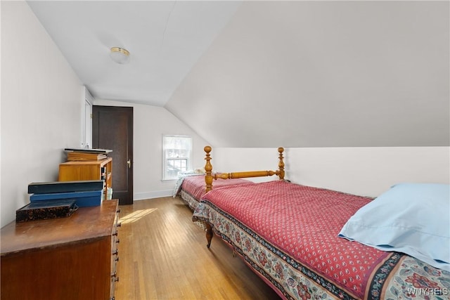 bedroom with hardwood / wood-style flooring and vaulted ceiling