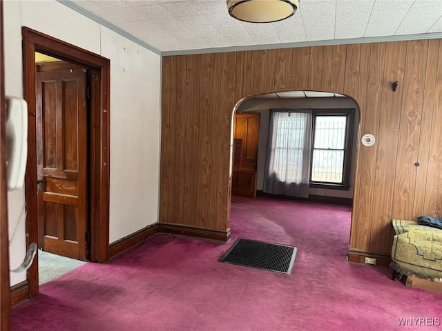 interior space featuring wooden walls and dark carpet