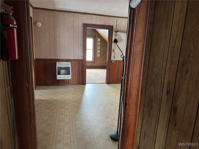 corridor featuring heating unit, crown molding, and wood walls