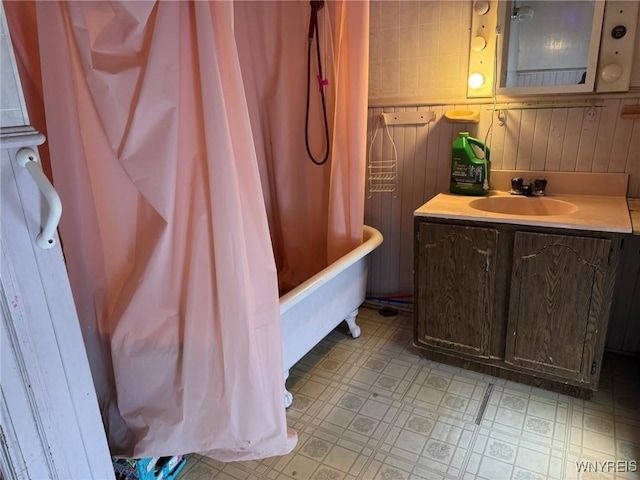 bathroom featuring shower / tub combo with curtain, vanity, and wooden walls