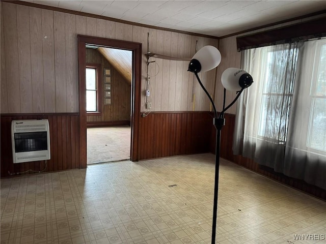 entryway with heating unit, crown molding, and wooden walls