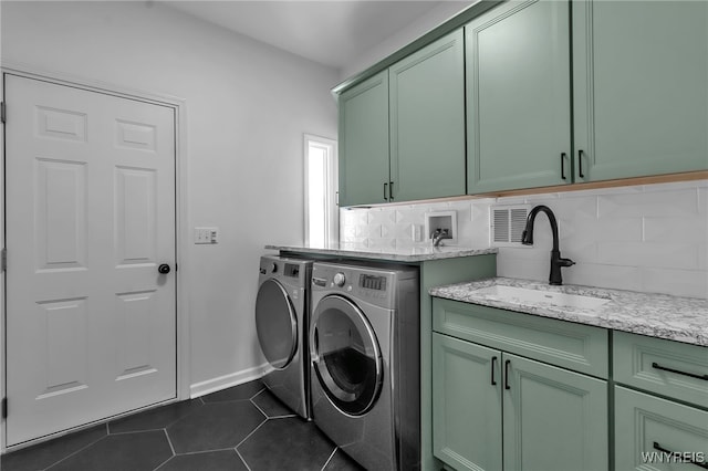 washroom featuring independent washer and dryer, cabinets, dark tile patterned flooring, and sink