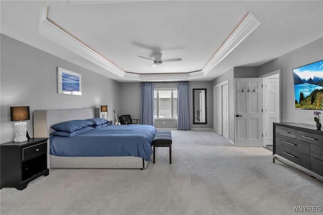 carpeted bedroom featuring ceiling fan, ornamental molding, and a tray ceiling