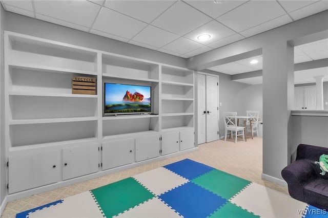 recreation room with built in shelves and light colored carpet