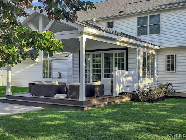 rear view of house featuring outdoor lounge area, a deck, and a lawn