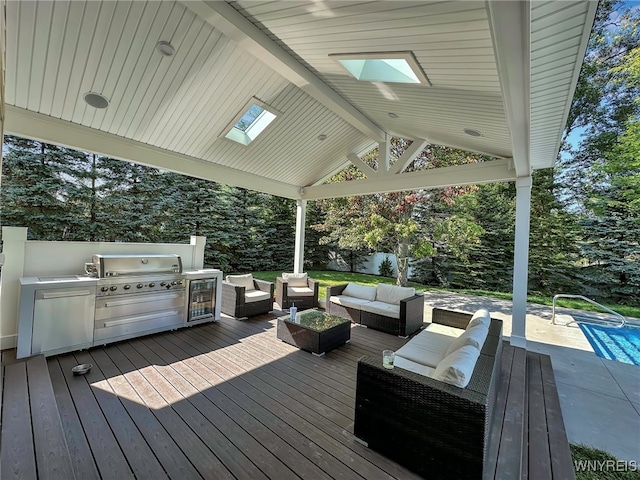 wooden deck featuring exterior kitchen, a gazebo, outdoor lounge area, and a grill