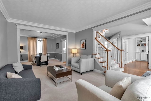 carpeted living room with ornamental molding and a chandelier