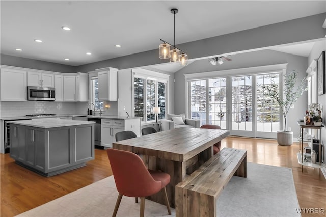 dining area with sink, light hardwood / wood-style floors, and a chandelier