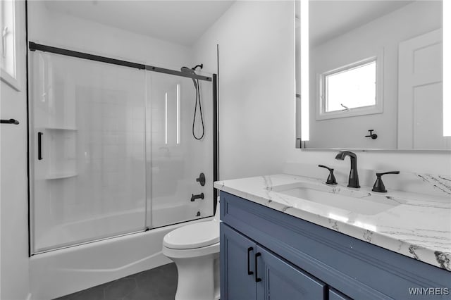 full bathroom featuring enclosed tub / shower combo, vanity, toilet, and tile patterned flooring