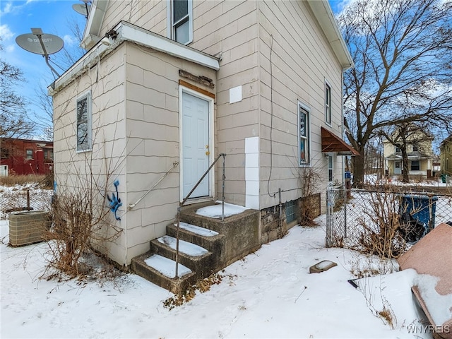 view of snow covered exterior with cooling unit