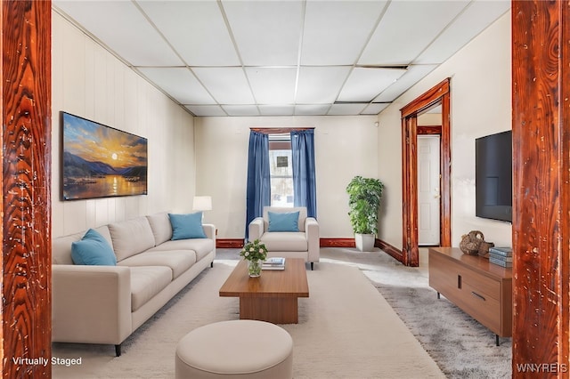 living room featuring light colored carpet and a paneled ceiling