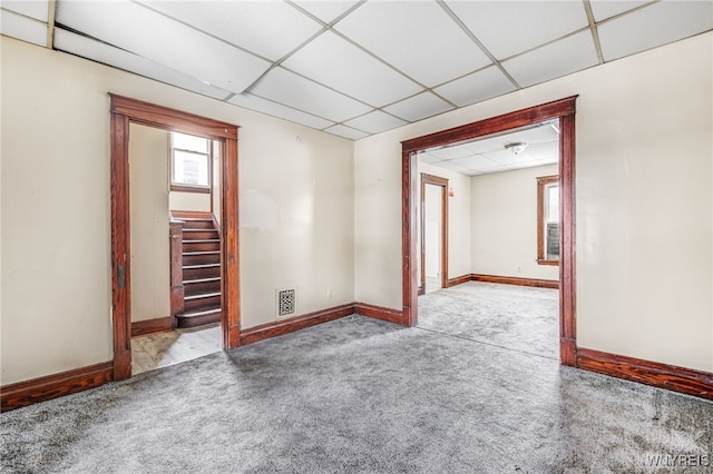 unfurnished room with a paneled ceiling and light carpet