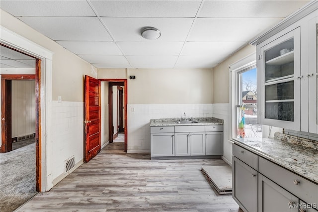 bathroom with wood-type flooring, sink, and a paneled ceiling