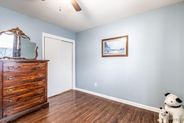 unfurnished bedroom with ceiling fan, dark hardwood / wood-style flooring, and a closet