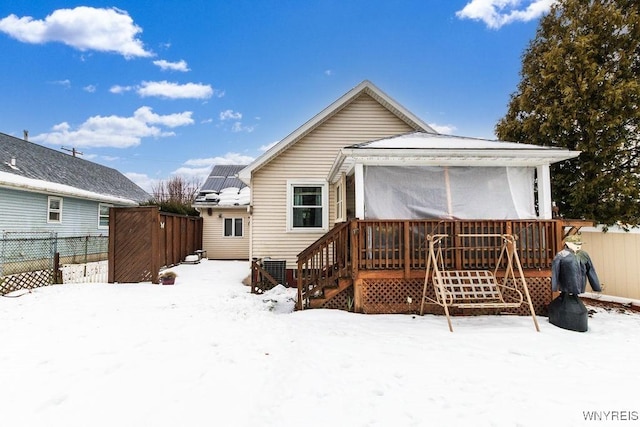 snow covered rear of property featuring a wooden deck