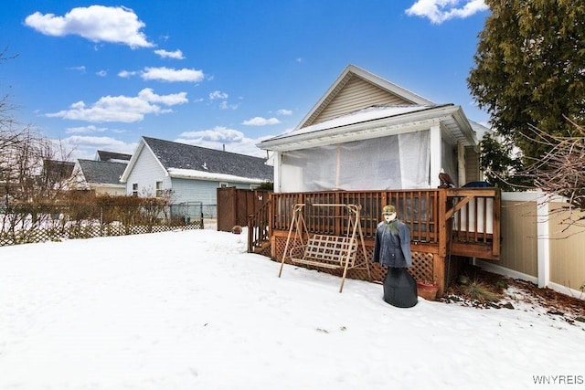 snow covered rear of property featuring a deck