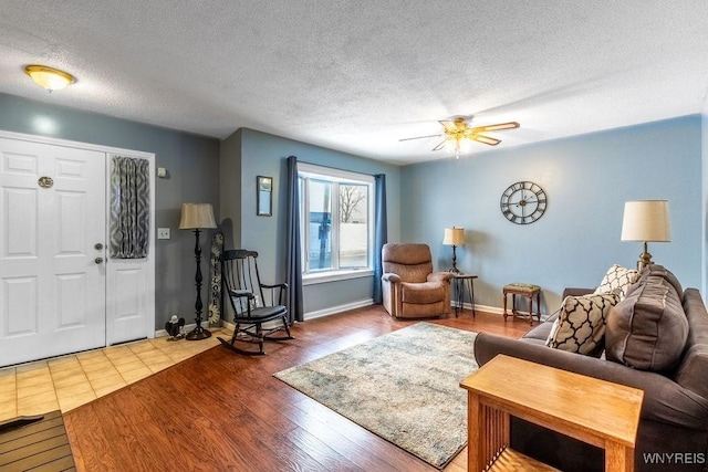 living room with wood-type flooring, ceiling fan, and a textured ceiling