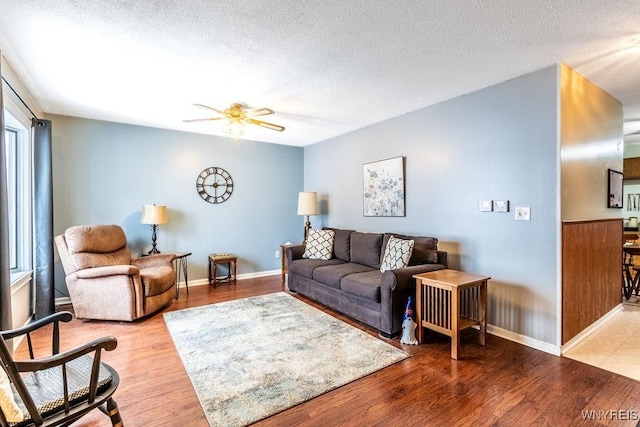 living room with wood-type flooring, ceiling fan, and a textured ceiling