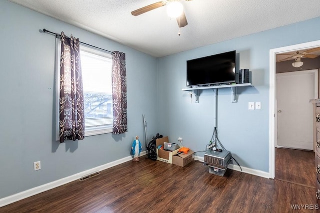 interior space featuring ceiling fan, dark hardwood / wood-style flooring, and a textured ceiling