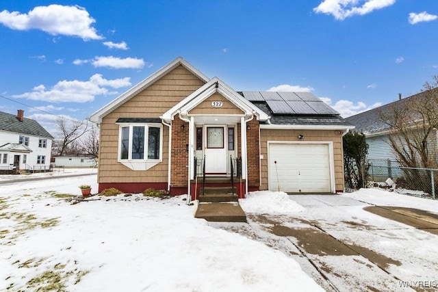 view of front of property featuring a garage and solar panels