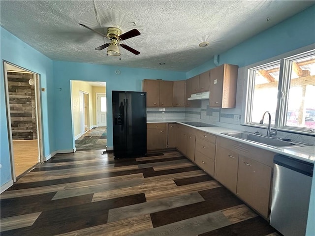 kitchen with sink, decorative backsplash, black appliances, dark wood-type flooring, and a textured ceiling