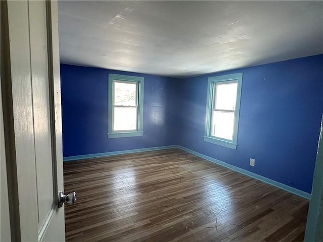 unfurnished room featuring dark hardwood / wood-style flooring and a wealth of natural light