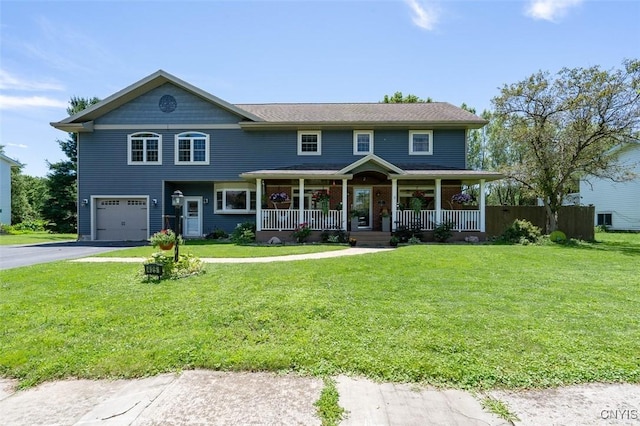 view of front of house featuring a garage, a front yard, and covered porch