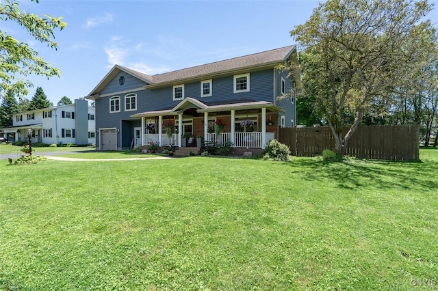 view of front of home featuring a porch, a garage, and a front yard