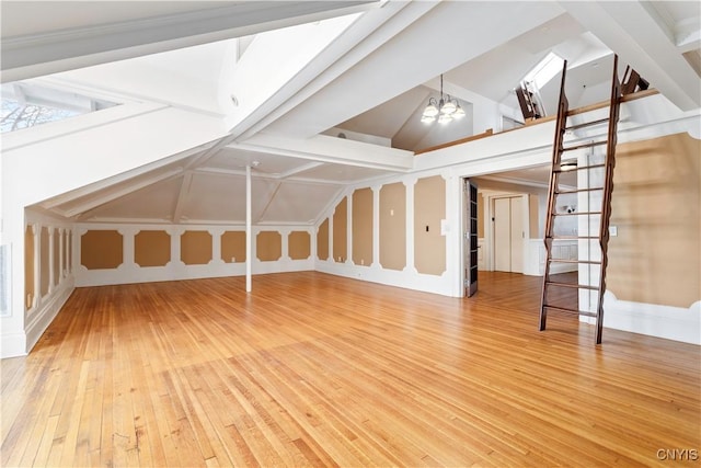 1208 James St, Syracuse, NY 13203 - bonus room with lofted ceiling, a notable chandelier, and hardwood / wood-style flooring