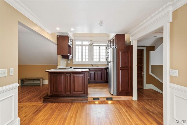 1208 James St, Syracuse, NY 13203 - kitchen featuring crown molding, light hardwood / wood-style flooring, stainless steel refrigerator, black electric cooktop, and pendant lighting